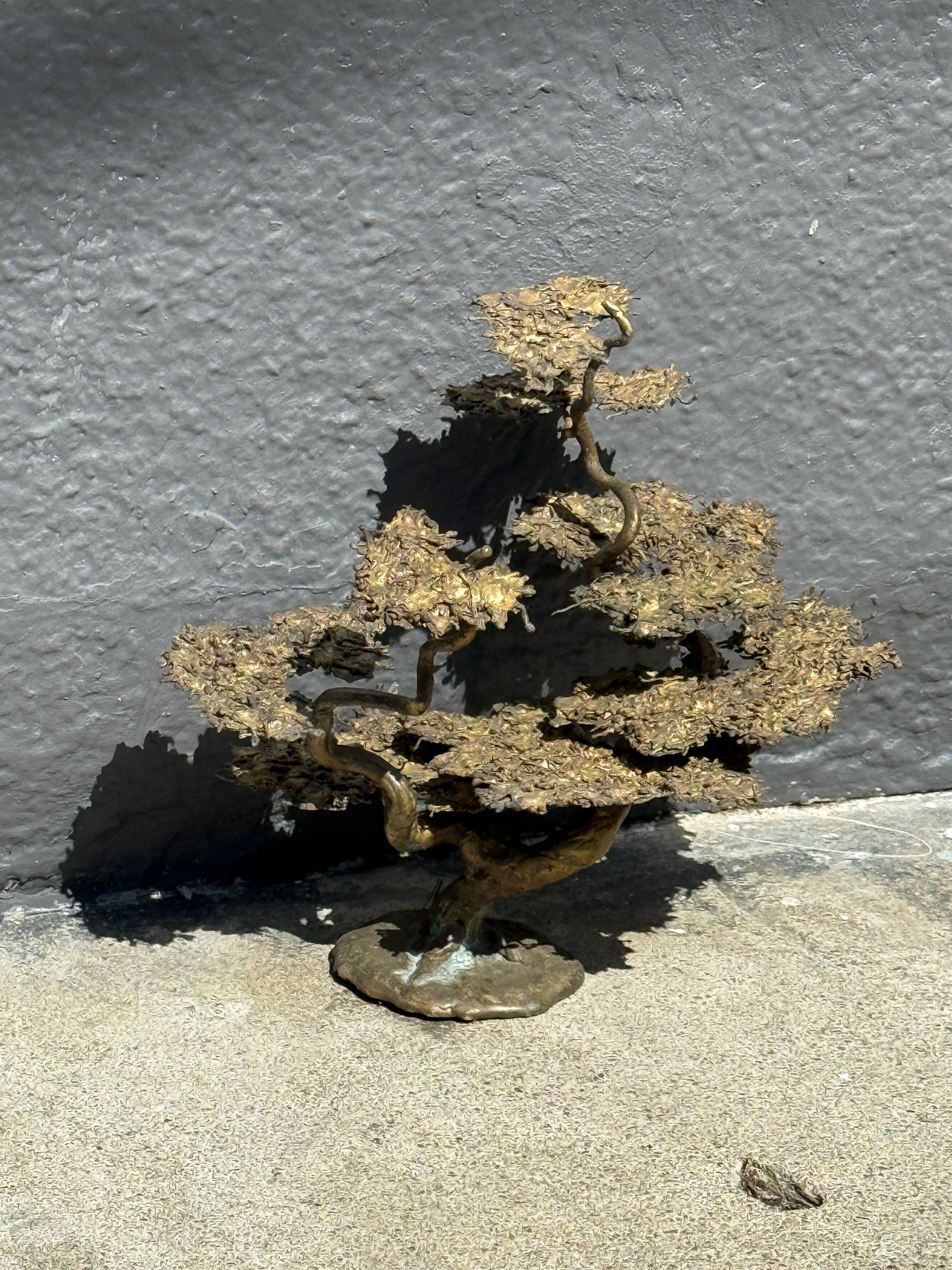 a copper or bronze bonzai tree statue