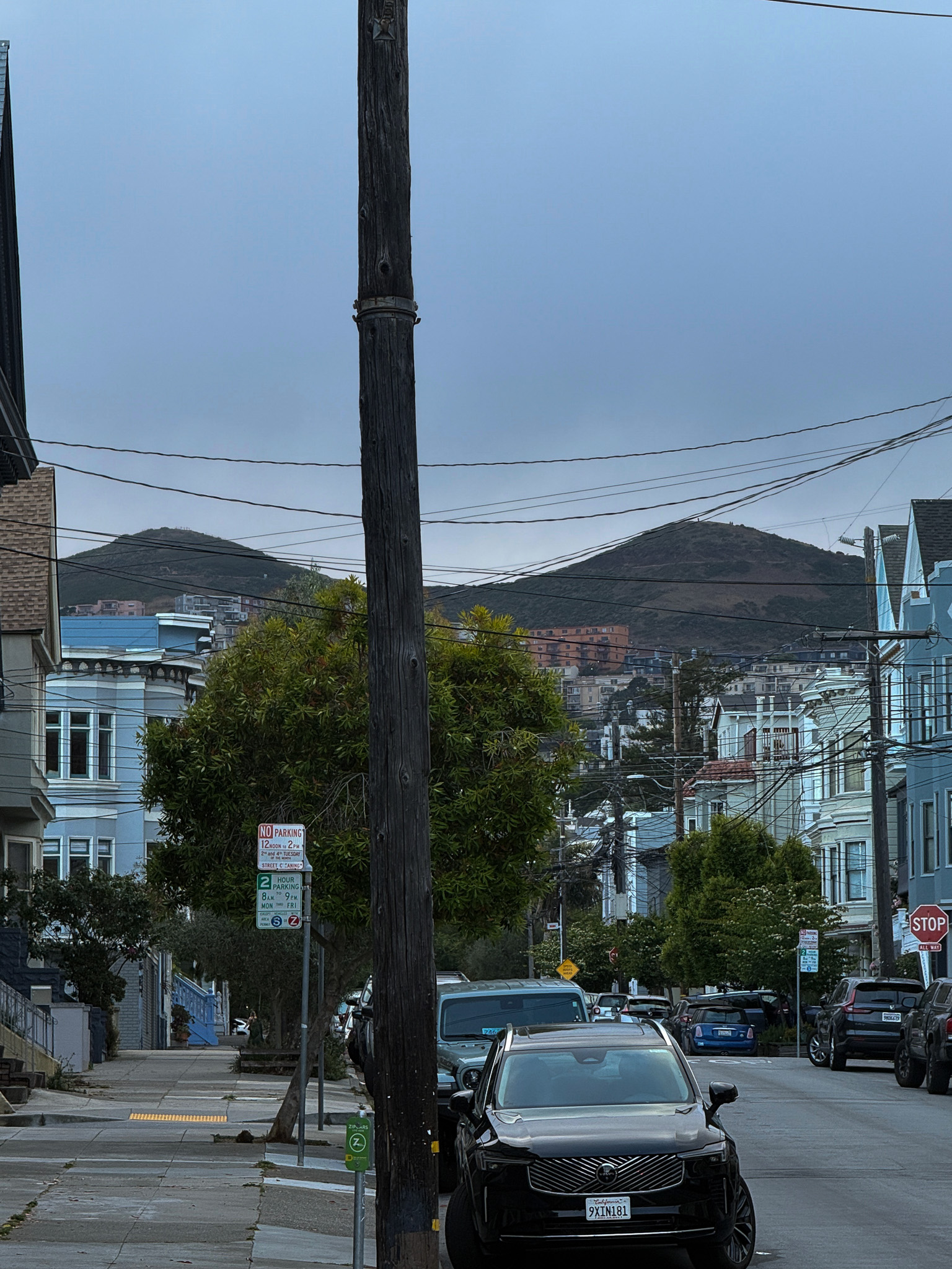 View of Twin Peaks in the background behind classic Victorian San Francisco houses with tons of wires going everywhere